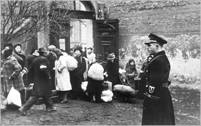 A Polish policeman supervises a deportation action in the Krakow ghetto